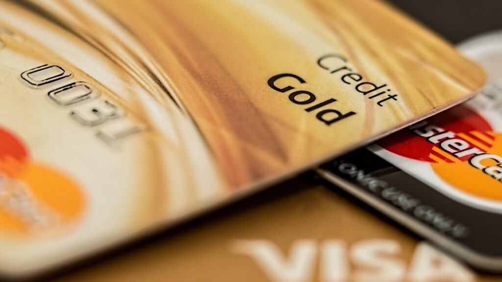 Close-up of stacked credit cards, including a gold card, Visa, and Mastercard