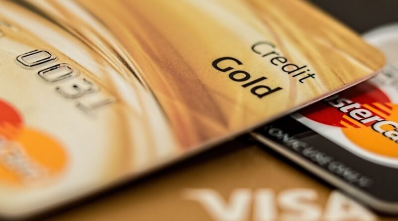 Close-up of stacked credit cards, including a gold card, Visa, and Mastercard