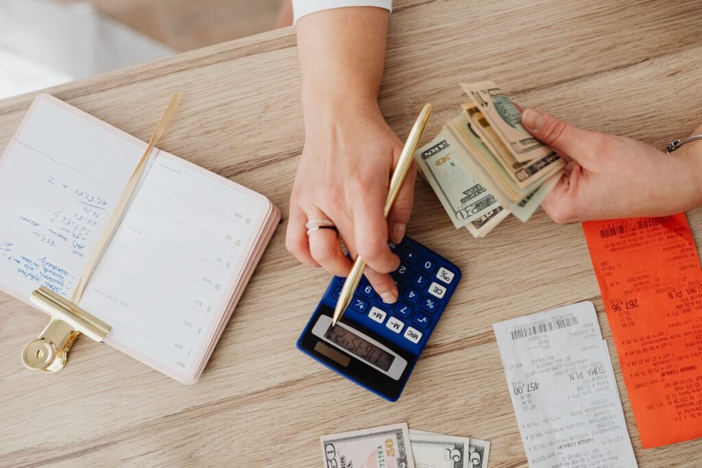 Person holding paper bills while using a calculator, representing decisions about old time-barred debt