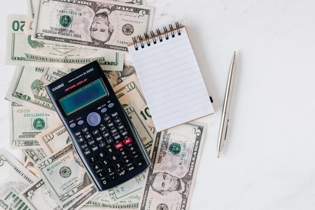 Flat lay of US dollar bills with a calculator and notebook for budgeting