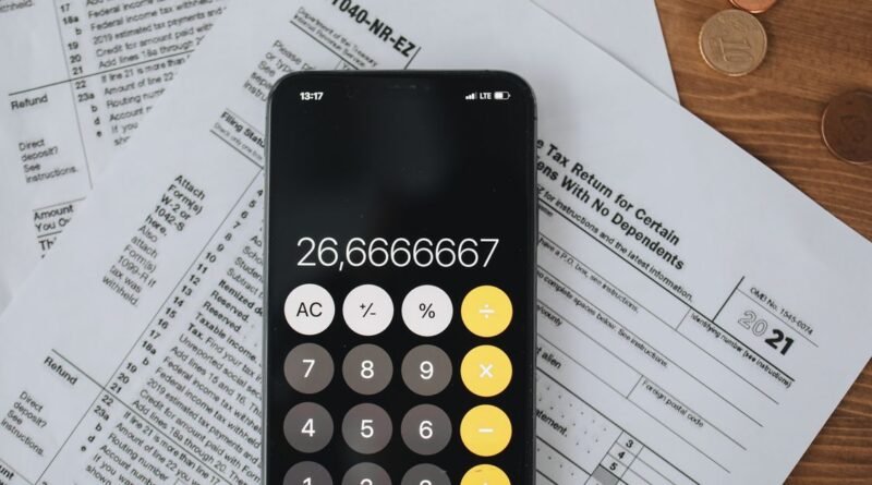Smartphone calculator over tax forms with coins on a wooden desk