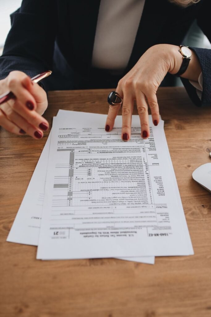 Hands examining tax forms on a wooden table