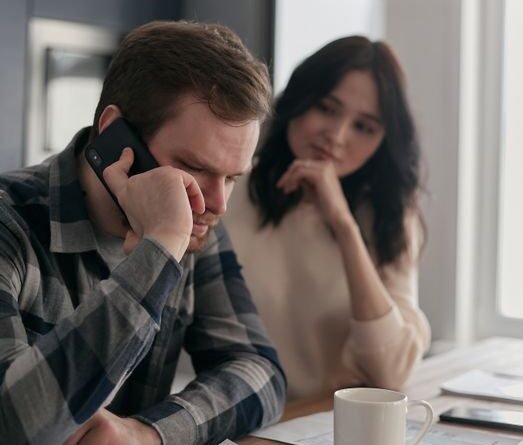 Worried couple reviewing bills and finances at a table at home