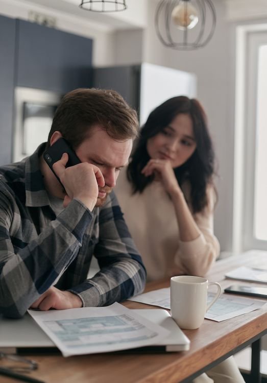 Worried couple reviewing bills and finances at a table at home