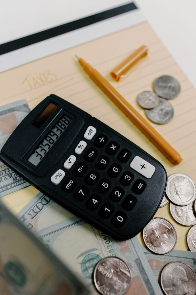 Calculator, cash, and coins on a desk representing the money at stake when evaluating debt relief offers