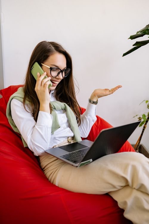Woman on a phone call with her credit card company while following a negotiation script on her laptop