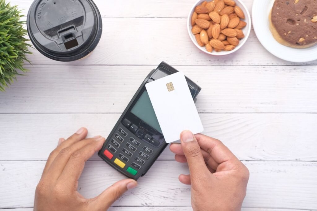 Person holding a credit card at a payment terminal